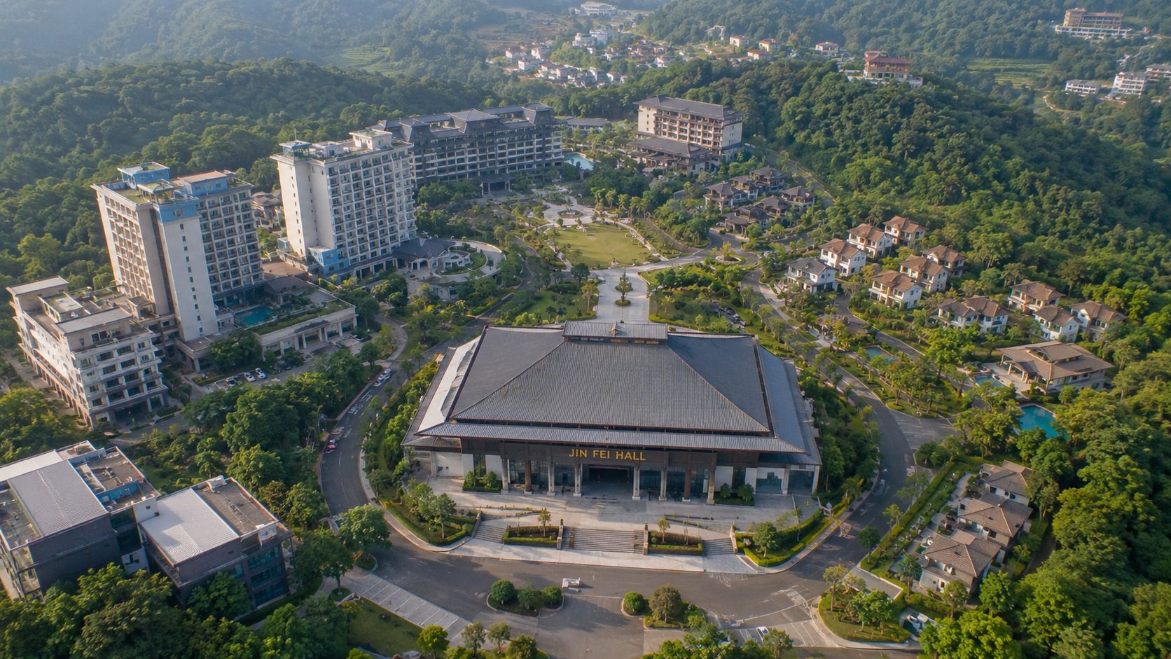 An aerial view of the grand Jin Fei Hall surrounded by lush greenery and resort buildings.